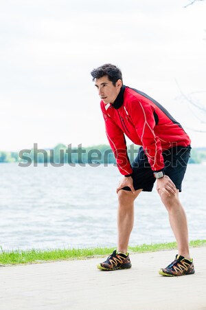 Woman and man at break from running in front of lake Stock photo © Kzenon