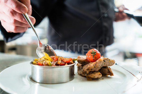 Chef finishing food on plate in restaurant kitchen Stock photo © Kzenon