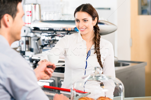 Beautiful waitress serving male customer with a cup of coffee fo Stock photo © Kzenon