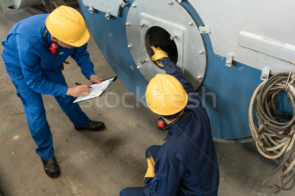 Expert checking the quality of manufactured boilers Stock photo © Kzenon