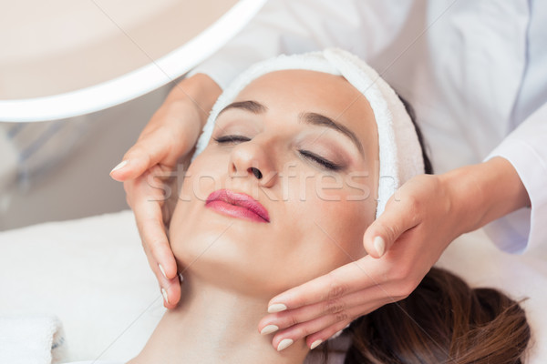 Beautiful woman relaxing during facial massage for rejuvenation  Stock photo © Kzenon