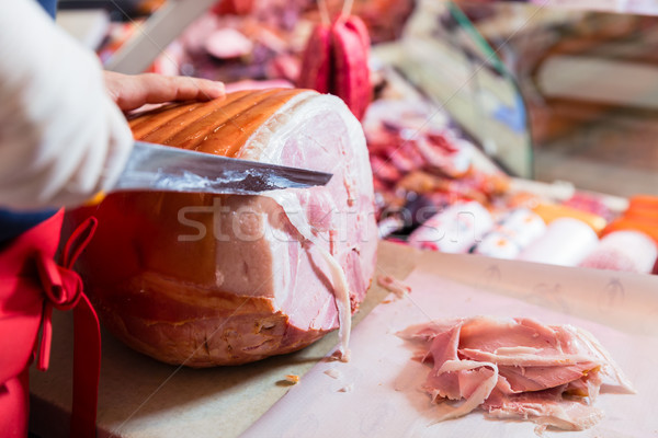 Experienced butcher shop assistant cutting ham Stock photo © Kzenon