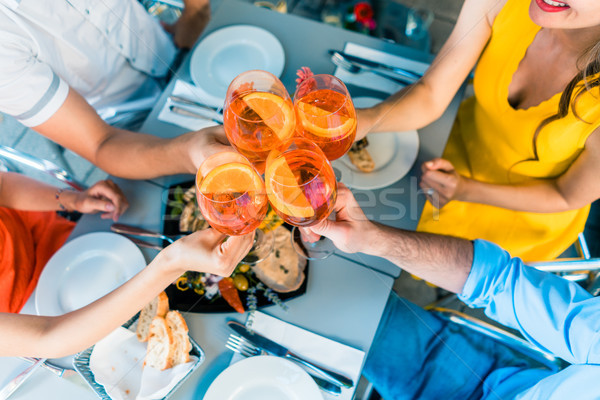 High-angle view of the hands of four friends toasting during lunch Stock photo © Kzenon