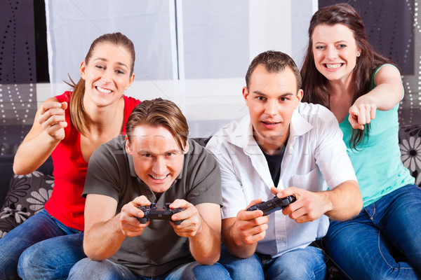 Friends sitting in front of game console box Stock photo © Kzenon