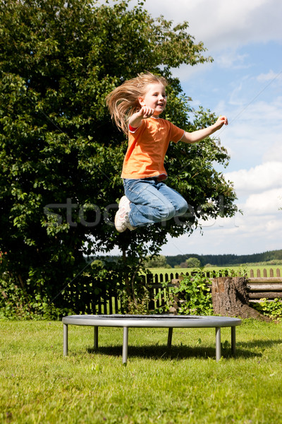 Girl child on trampoline in the garden Stock photo © Kzenon