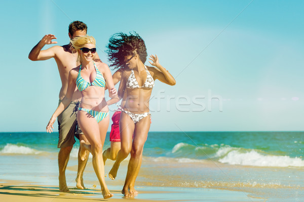 Vrienden lopen strand vakantie vier mannen Stockfoto © Kzenon