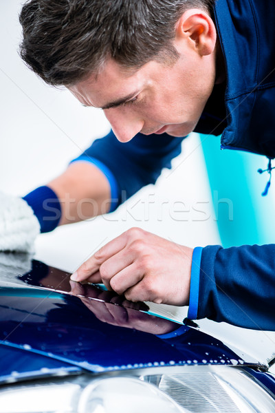 Hard-working man polishing car with white microfiber mitt Stock photo © Kzenon