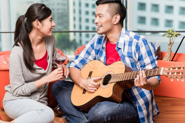 After moving together young man plays love song for his girlfrie Stock photo © Kzenon