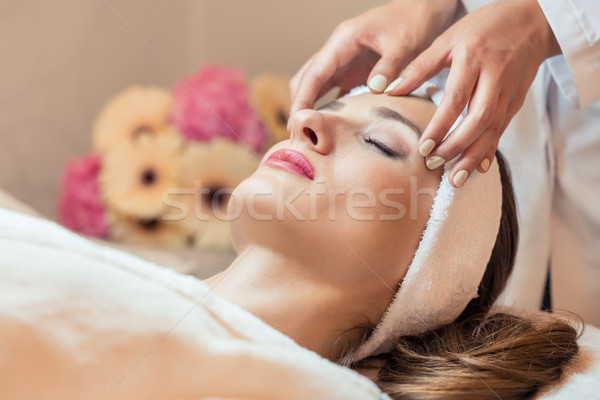 Beautiful woman relaxing during rejuvenating facial massage in a Stock photo © Kzenon