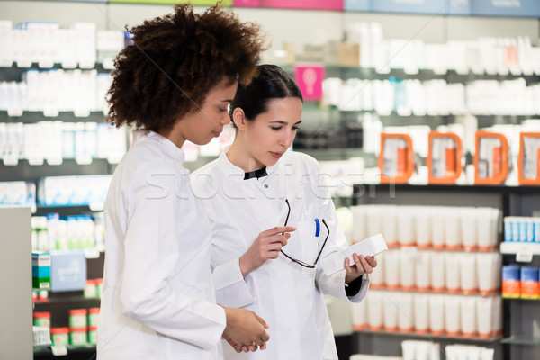Side view of two dedicated pharmacists in a contemporary pharmacy Stock photo © Kzenon