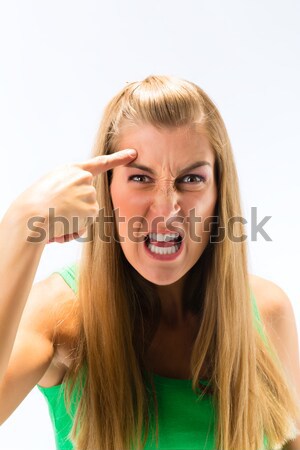 Depressed woman makes handgun gesture with fingers Stock photo © Kzenon