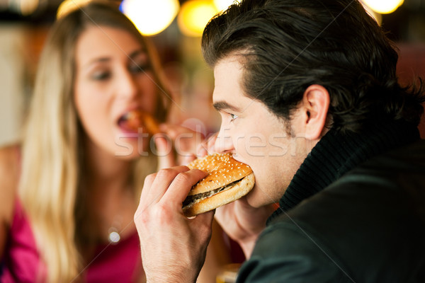 Couple in Restaurant eating fast food Stock photo © Kzenon