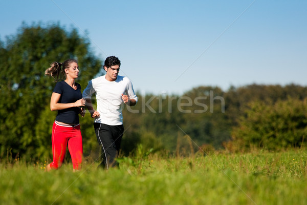 Sport Coppia jogging prato estate giovani Foto d'archivio © Kzenon