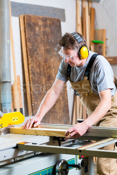 Carpenter using electric saw in carpentry Stock photo © Kzenon