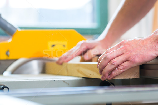 Carpenter using electric saw in carpentry Stock photo © Kzenon