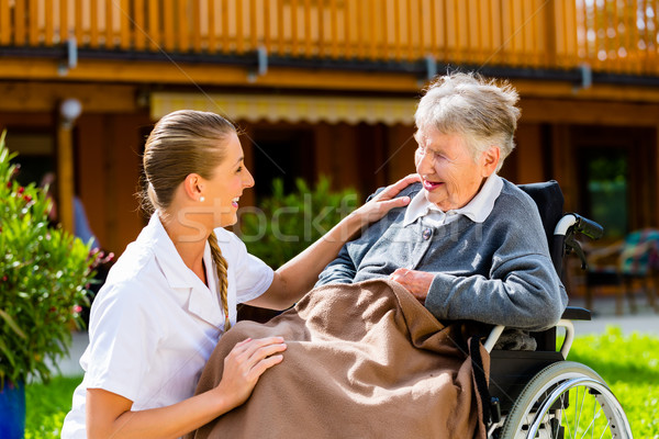 Foto stock: Enfermeira · empurrando · senior · mulher · cadeira · de · rodas · andar