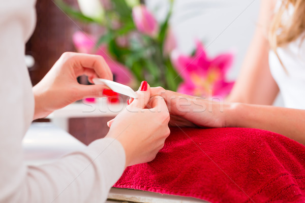 Woman at manicure in nail parlor with file Stock photo © Kzenon