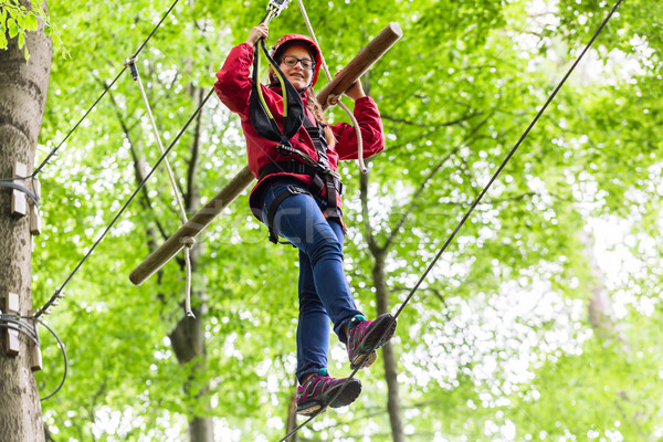 Child reaching platform climbing in high rope course Stock photo © Kzenon
