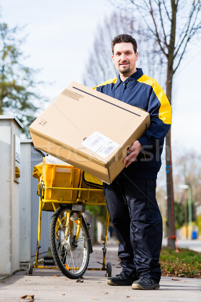 Postman delivering packet wrapped as present Stock photo © Kzenon