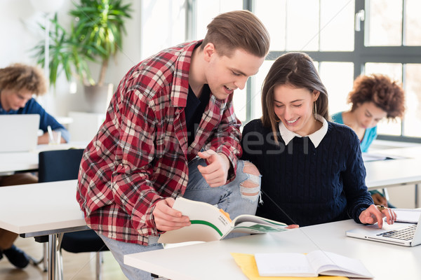 Friendly student helping his classmate by explaining and showing the answer Stock photo © Kzenon
