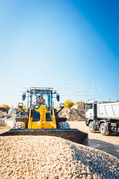 Construction workers doing earthworks with wheel loader Stock photo © Kzenon