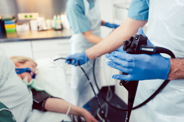 Doctor inserting camera of gastroscope into mouth of patient Stock photo © Kzenon