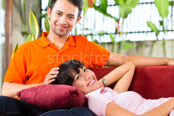Asian couple in spacious home on sofa Stock photo © Kzenon