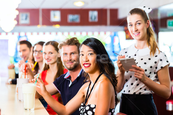 People in American diner or restaurant with milk shakes Stock photo © Kzenon