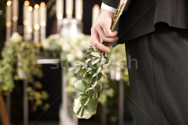 Grief - man with white roses at urn funeral Stock photo © Kzenon