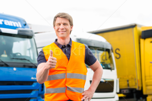 Forwarder or driver in front of trucks in depot Stock photo © Kzenon