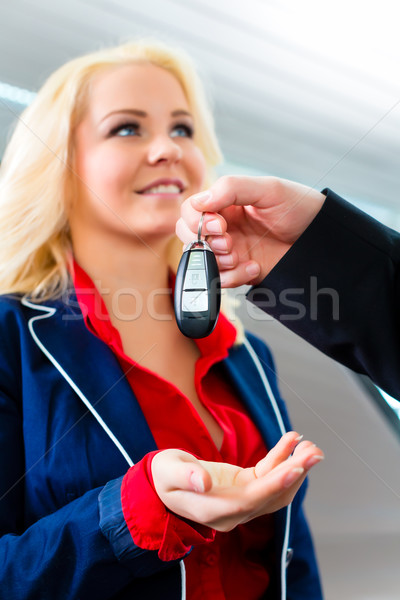 Woman with key to new auto in car dealership Stock photo © Kzenon