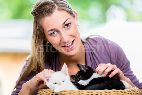 Portrait of happy young woman stroking cute kittens in basket Stock photo © Kzenon