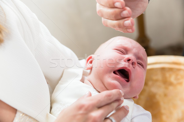 Baby is crying at christening while the priest pours holy water  Stock photo © Kzenon