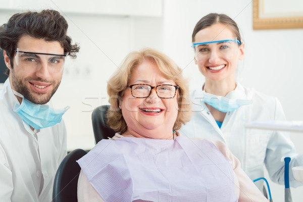 Сток-фото: Стоматологи · пациент · хирургии · глядя · камеры · улыбаясь