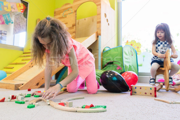 Cute girl building a structure in balance during playtime at the kindergarten Stock photo © Kzenon
