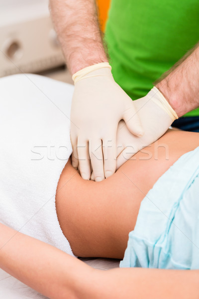 Practitioner at colon therapy massaging abdomen Stock photo © Kzenon