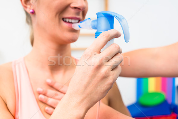 Woman taking pulmonary function test with mouthpiece in her hand Stock photo © Kzenon