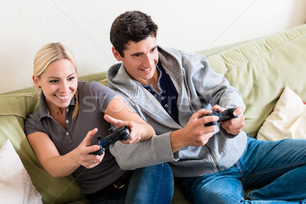 Funny young couple playing together a video game on console at h Stock photo © Kzenon