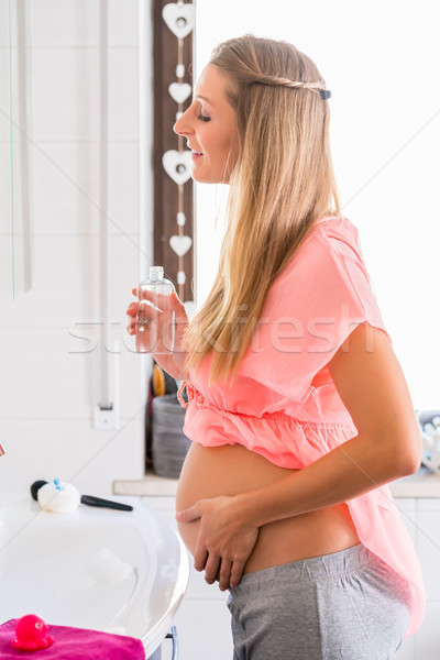Soon-to-be mum caring for skin at belly Stock photo © Kzenon