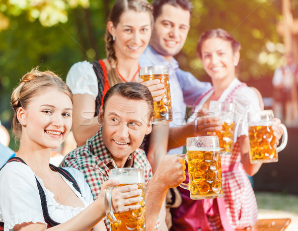 In Beer garden - friends drinking beer in Bavaria on Oktoberfest Stock photo © Kzenon