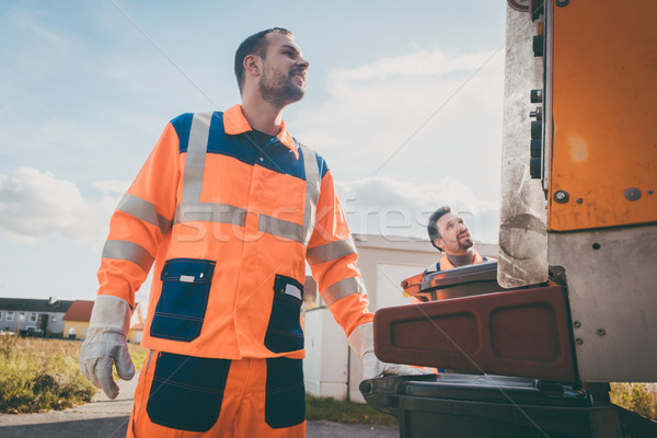Two refuse collection workers loading garbage into waste truck Stock photo © Kzenon