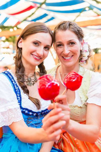 Friends in a beer tent holding candy apples Stock photo © Kzenon