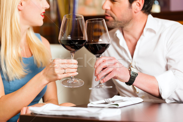 Attractive couple drinking red wine in restaurant or bar Stock photo © Kzenon