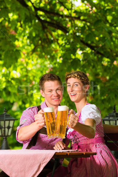 Happy Couple in Beer garden drinking beer Stock photo © Kzenon