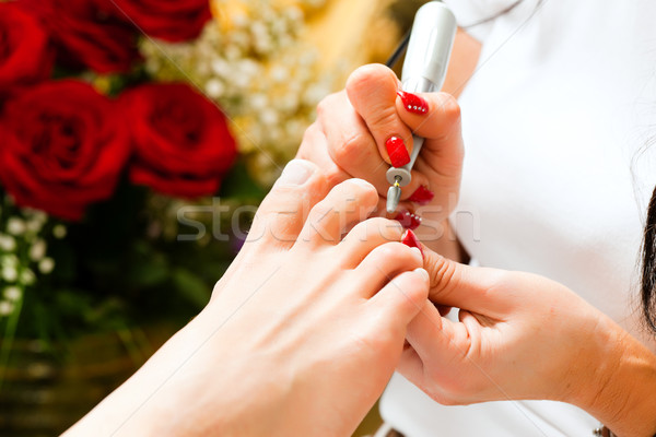 Woman in nail studio receiving pedicure Stock photo © Kzenon