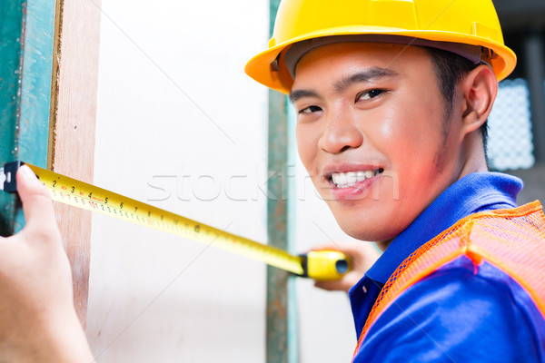 Builder or worker controlling wall on construction site Stock photo © Kzenon