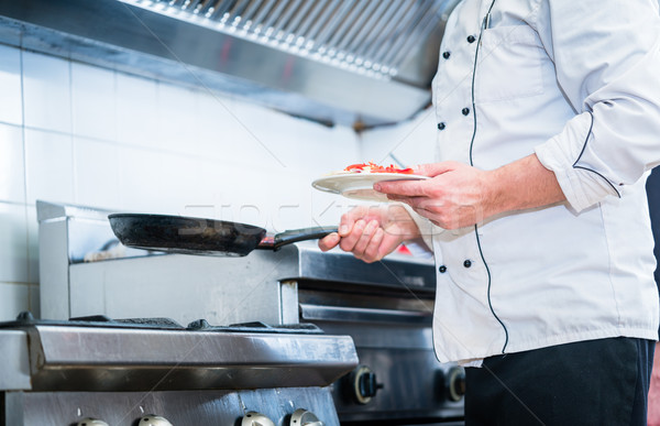 Chef with pan in restaurant kitchen Stock photo © Kzenon