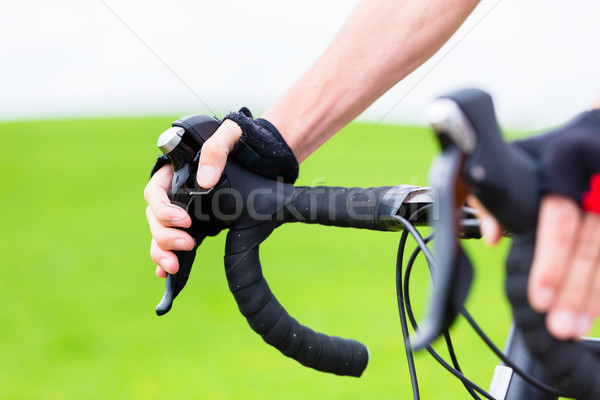 Sport man having Hands on handlebar of racing bike Stock photo © Kzenon