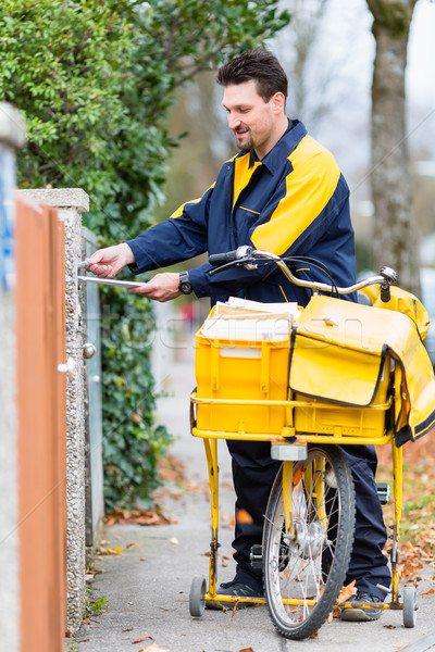 Postman delivering letters to mailbox of recipient Stock photo © Kzenon