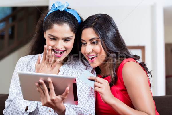 Two women browsing the internet on a tablet PC indoors Stock photo © Kzenon